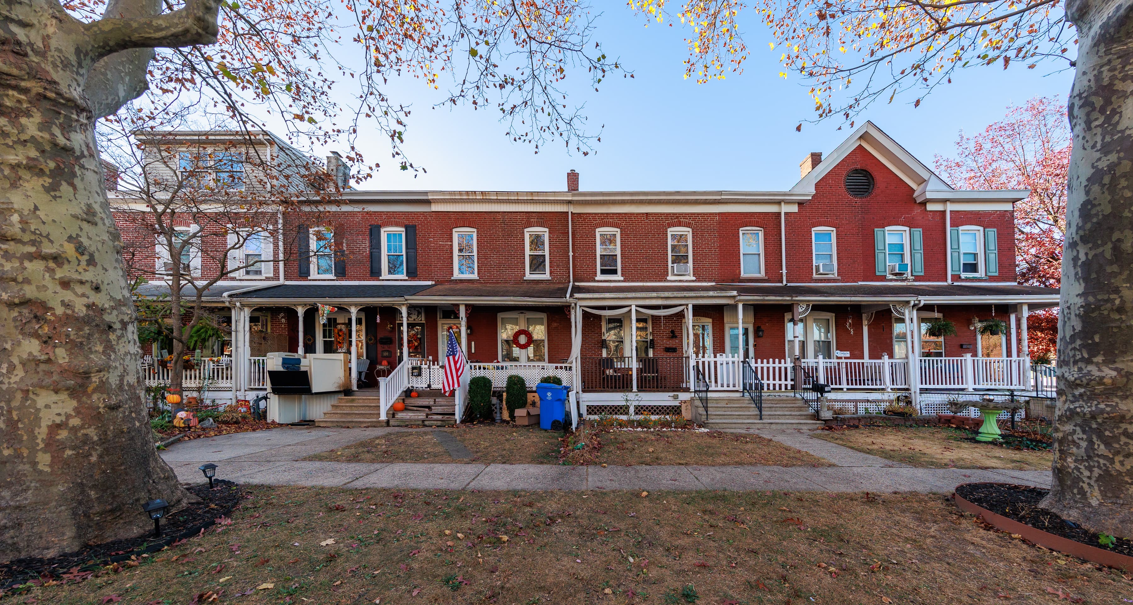 A terrace of identical two-storey brick company houses with front porches, on a street in the planned village of Roebling, New Jersey.