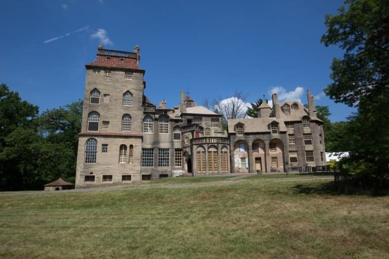 Fonthill Castle at Doylestown, a few miles east of Fountainville — a tall, irregular poured-concrete house of many differently shaped windows and towers, seen across open lawn.