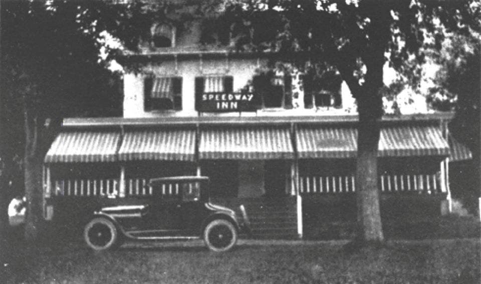 The Speedway Inn at Jamison, Pennsylvania, in an early photograph — a two-story inn behind a long striped awning, with a 1920s motor car drawn up under the trees.