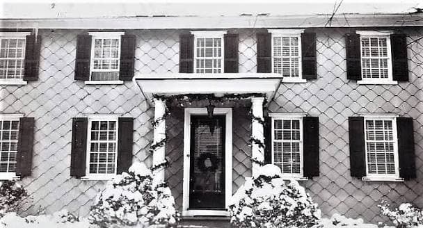 A house at Line Lexington, Pennsylvania, under snow — a shuttered colonial front with a wreath on the door and snow banked along the shrubs.