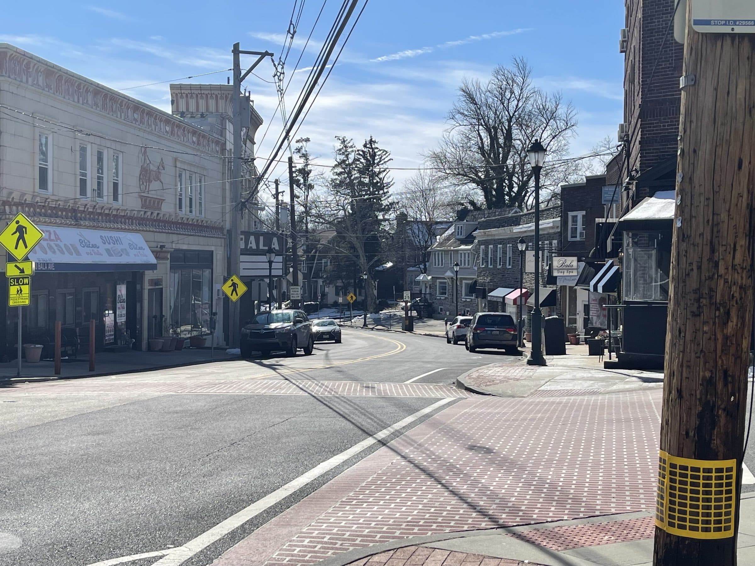 Bala Avenue in Bala Cynwyd, Pennsylvania, looking along the shopfronts and brick crossing toward the older houses beyond.