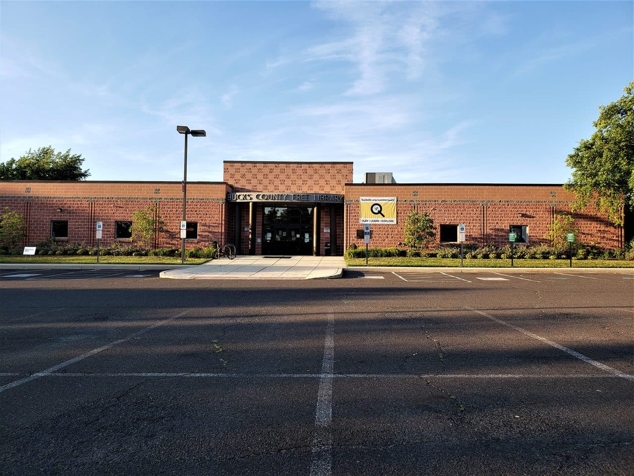 The Levittown branch of the Bucks County Free Library, a low red-brick building with a raised entrance bay, seen from its car park.