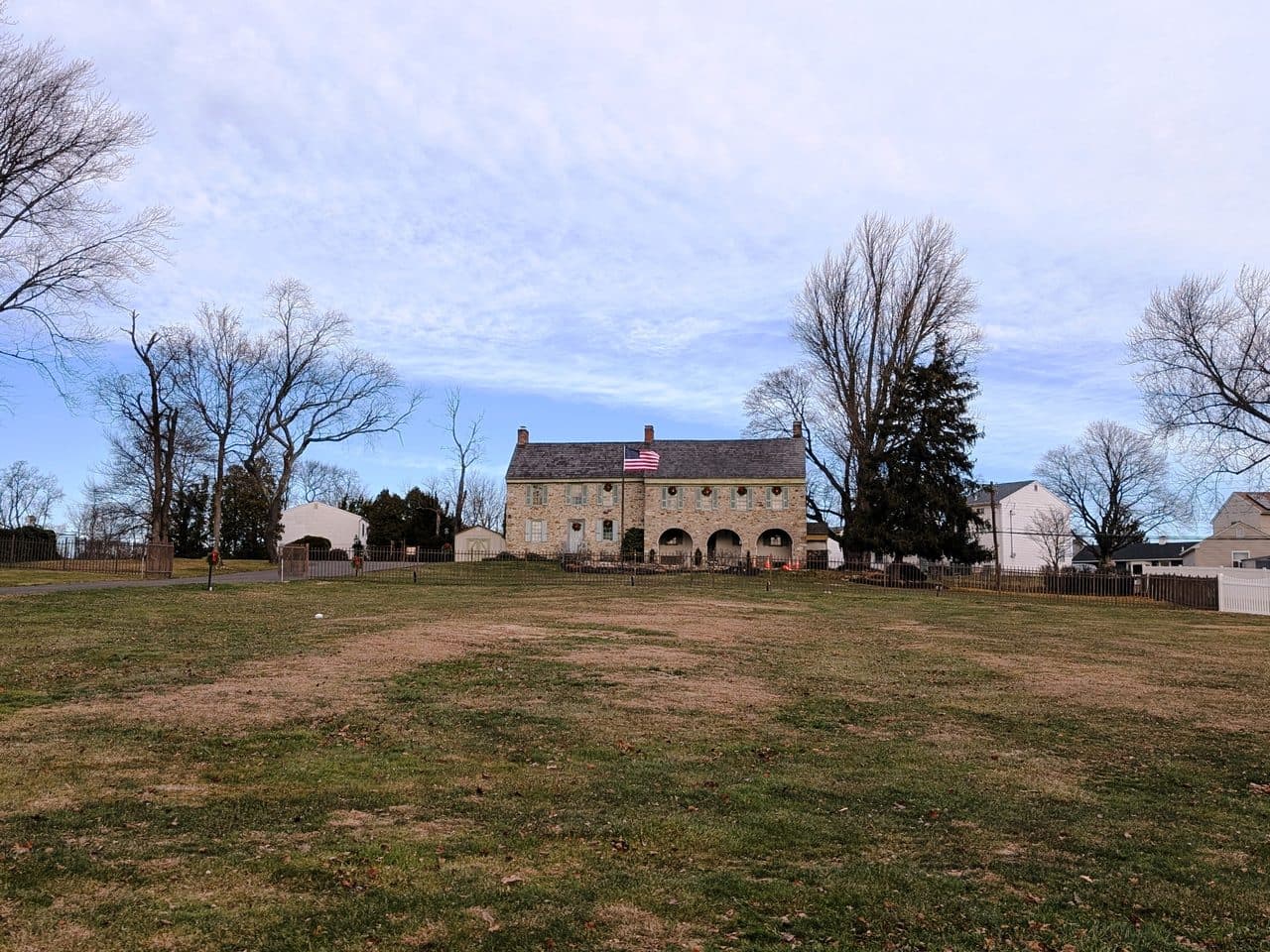 The historic Three Arches house at Fairless Hills, Pennsylvania, a stone building with three arched openings seen across an open field in winter.