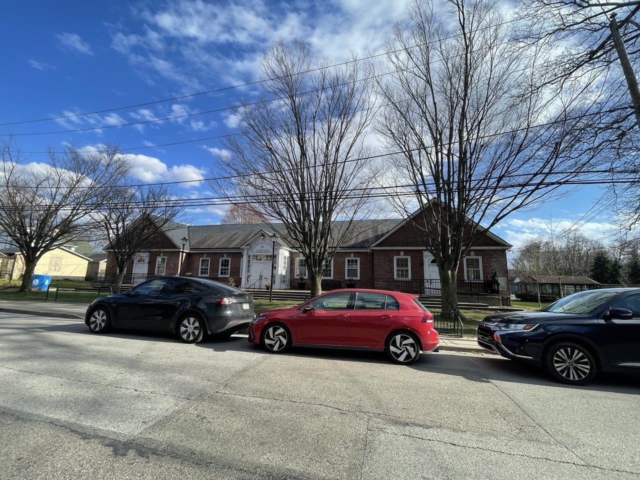 The Narberth Community Library in Narberth, Pennsylvania, a low brick building behind bare trees on a quiet street.