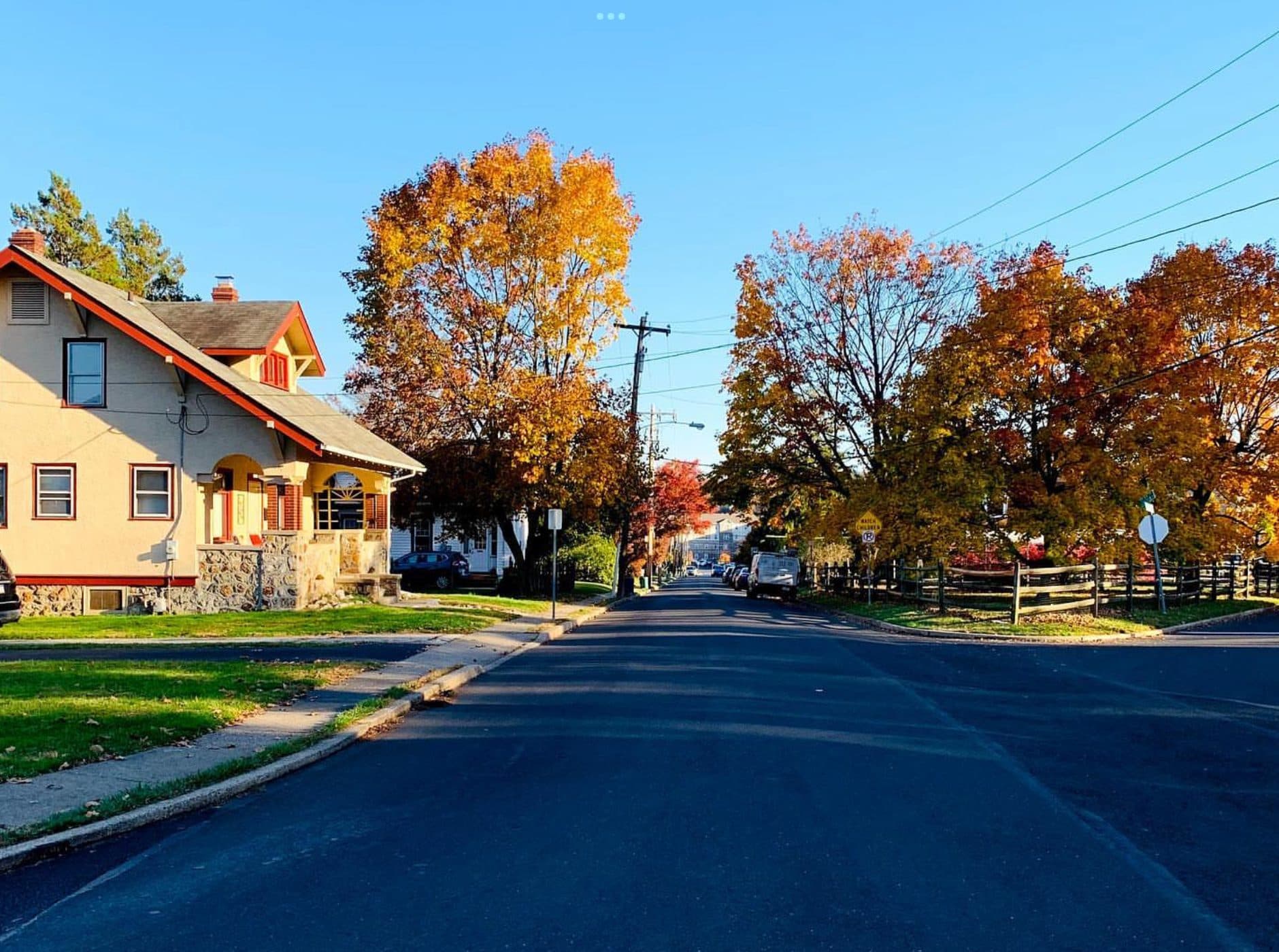 Looking south downhill along Grant Avenue in Willow Grove, Pennsylvania, past a cream stucco house with a deep porch, under autumn trees.
