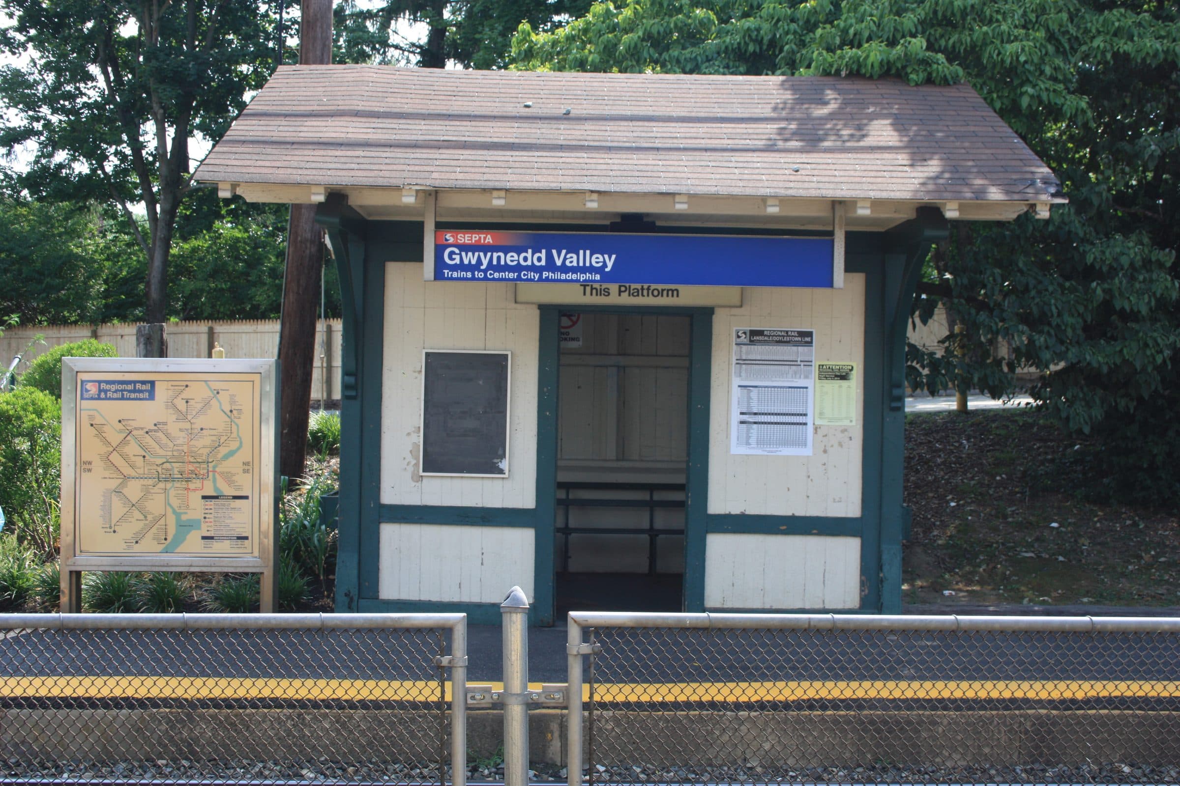 The inbound shelter at Gwynedd Valley station, Pennsylvania — a small clapboard waiting hut with a shingled roof under a SEPTA sign reading Gwynedd Valley.