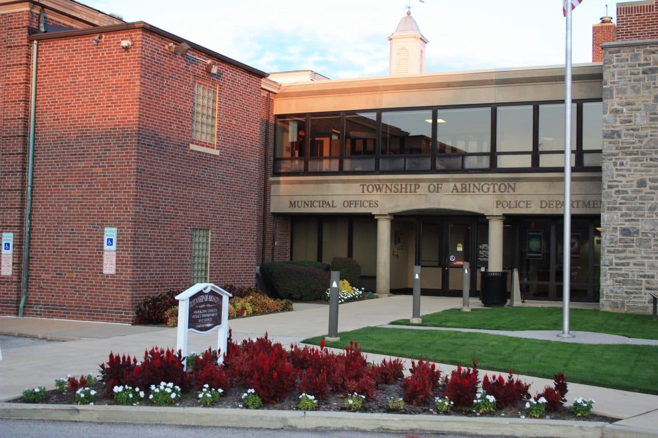 The Township of Abington municipal offices and police building in Montgomery County, Pennsylvania, brick and stone behind a flowerbed.