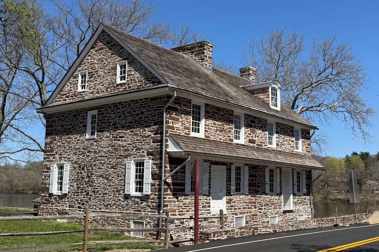 McConkey’s Ferry Inn at Washington Crossing Historic Park, a two-story fieldstone building with white shutters beside the road along the Delaware.
