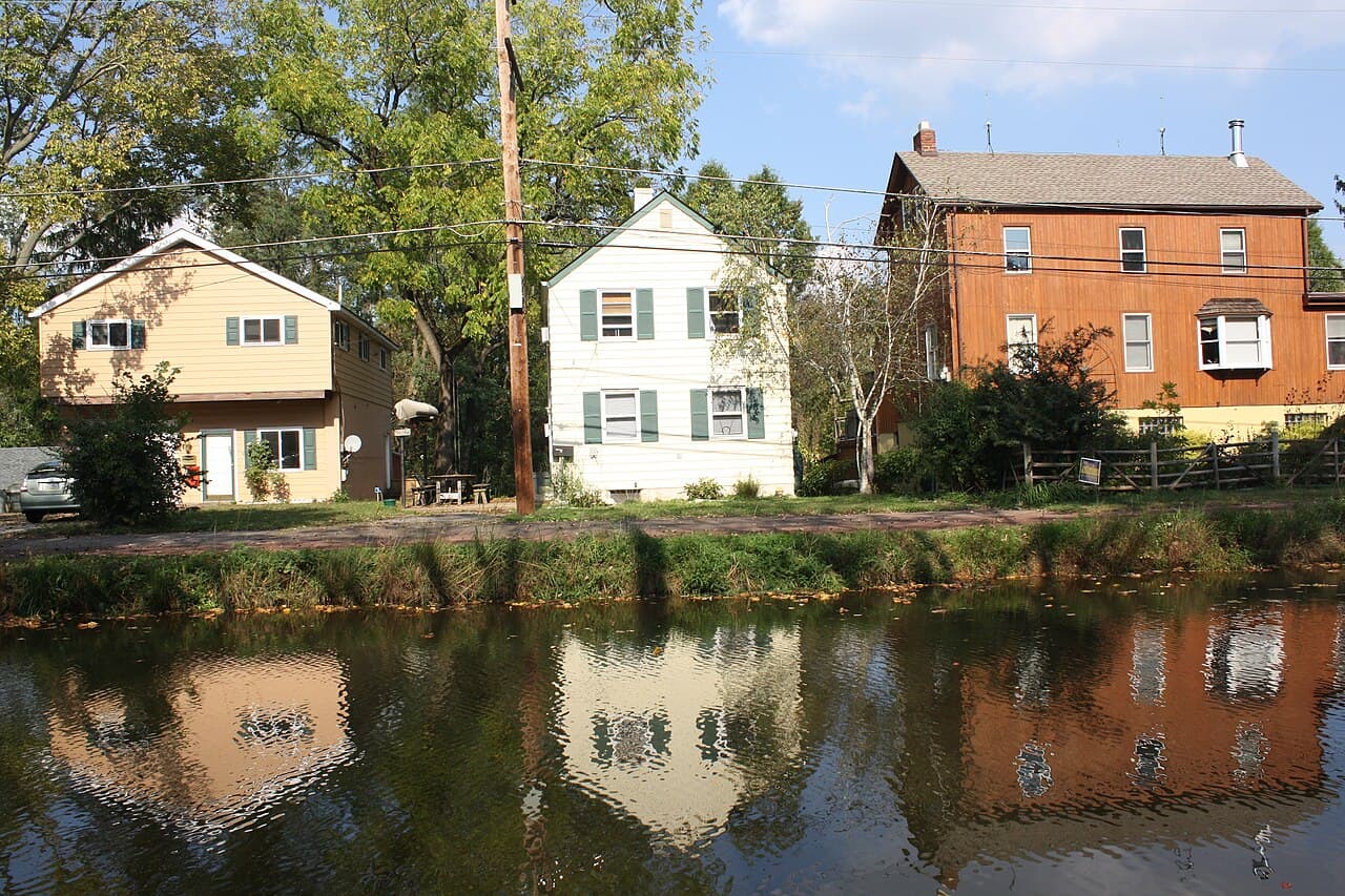Houses along the Delaware Canal in the Yardley Historic District, Yardley, Pennsylvania, reflected in the still water of the canal.